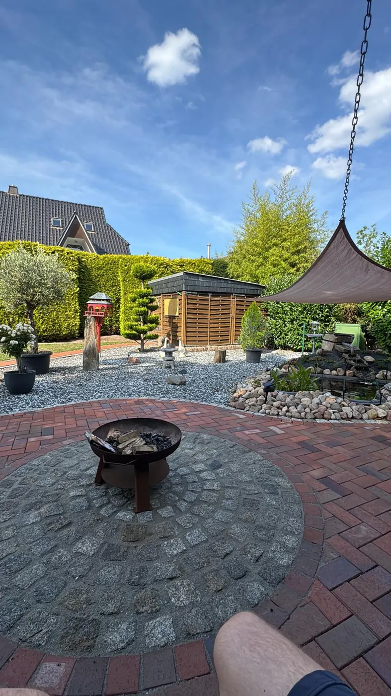 Fertiggestellter Gartenbereich mit Pflaster und Kiesfläche